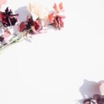 Minimalist flat lay of red and pink flowers on a white backdrop, perfect for romantic or wedding themes.